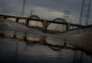 The iconic 6th Street Bridge connecting downtown Los Angeles with its eastern disticts is reflected in the Los Angeles River after its closure to traffic on January 27, 2016. The crumbling Sixth Street Viaduct that has appeared in scores of Hollywood productions will be closed and demolished due to safety concerns after its concrete has become weakened by a rare chemical reaction. / AFP / Mark Ralston        (Photo credit should read MARK RALSTON/AFP/Getty Images)